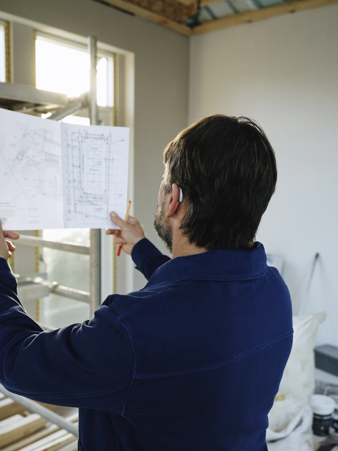 Man bekijkt een bouwplan in een kamer in afwerking